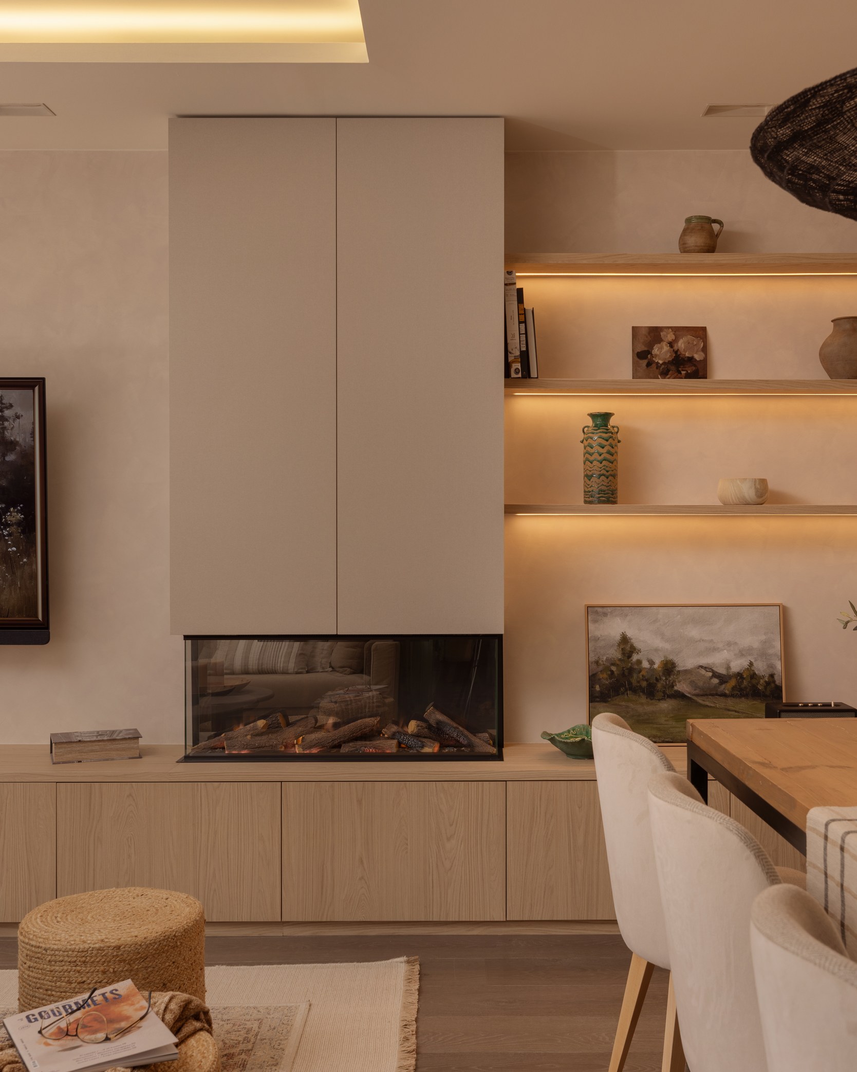 Salón con chimenea y estanterías iluminadas, proyecto de interiorismo en Barcelona